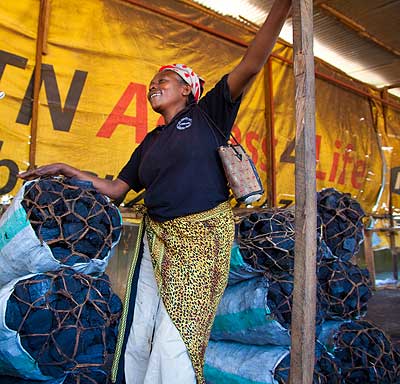 A woman at her charcoal vending stole in Kigali. Police have cautioned charcoal burners in Bugesera District against illegal felling of trees.  The New Times/ File.