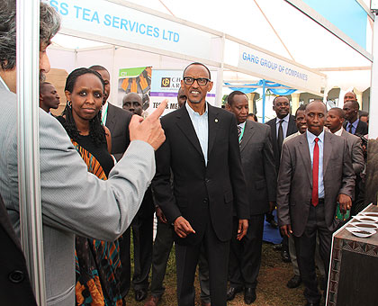 President Kagame and other officials, including Agriculture minister Agnes Kalibata (2L), listen to an exhibitor during  the Second Tea Convention and Exhibition in Kigali yesterda....