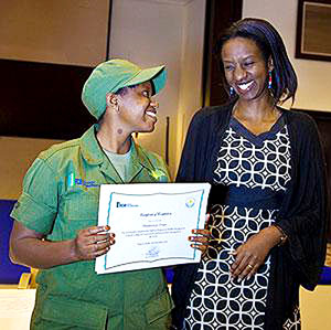 Tourism director Rica Rwigamba (R) awards a student at Kitabi. The New Times/ File.