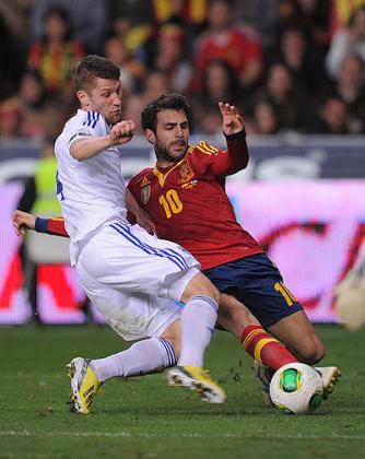 Cesc Fabregas (R) of Spain is tackled by Joona Toivio of Finland during the FIFA 2014 World Cup Qualifier at estadio El Molinon. Net photo.