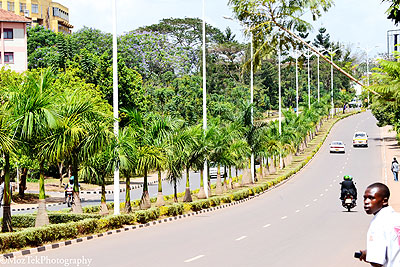 Kampal: A rolex maker in a typical dingy setting Kampala, a street on rainy day. Above is a neat Kigali street.