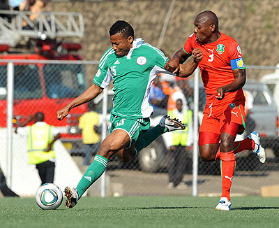 Super Eagles striker Ike Uche (L) battles Malawi captain Joseph Kamwendo in the first leg. Net photo