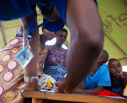 A Ministry of Disaster Preparedness and Refugee Affairs official registers evictees at Rusumo Border post yesterday.