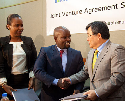 Minister Nsengimana (C) and Kim seal the deal with a handshake as RDBu2019s Akamanzi looks on. The New Times/T. Kisambira