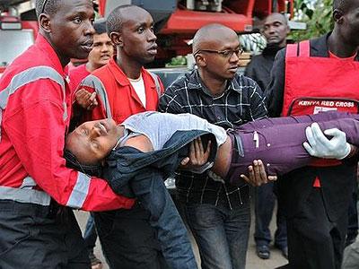 This woman who had been held by the gunmen was carried out of the building in a state of shock by the emergency services. Net photo