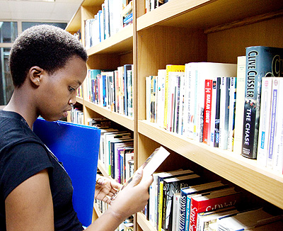 A student searches for books in a Kigali Public Library. The New Times/ File.