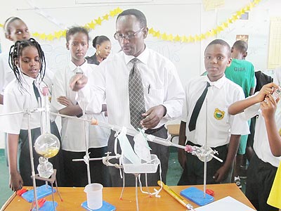 A teacher takes his students through chemical experiment. The New Times/ Timothy Kisambira.