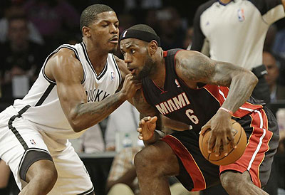 Brooklyn Nets' Joe Johnson (L) defends Miami Heat's Lebron James during the first half. Net photo.