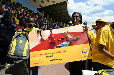 Epiphanie Nyirabarame  (left) receiving her dummy cheque of Rwf500,000 for winning the womenu2019s 21km race.  Times Sport / Don de Dieu Mugisha.