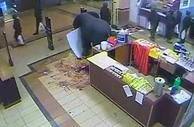 The still image shows men in fatigues carrying shopping bags. Net photo. 