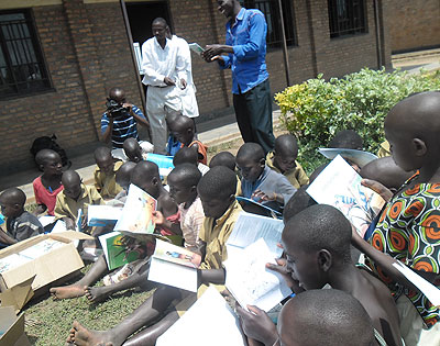 Pupils read books donated by Bakeme Editions. The New Times/ Susan Babijja.