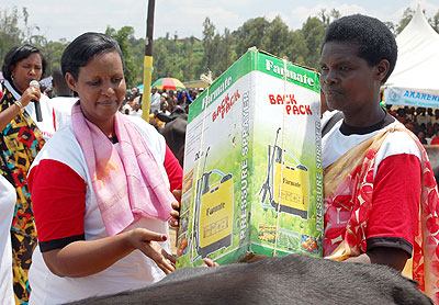 Gasinzigwa (L) hands over a pump spray to one of the beneficiaries. The New Times/ JP Bucyensenge.