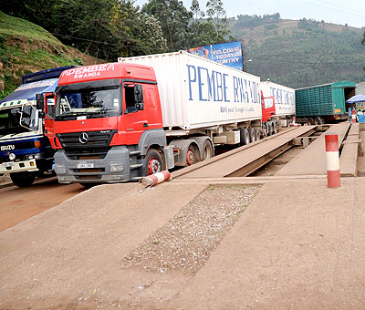 Among some of the resolutions was that all Partner States will comply with the instructions that transit cargo will be weighed once at the point of entry into each member state territory. Above, trucks cross the Rwanda - Uganda border of Gatuna and below flags of the four countries  The New Times/File