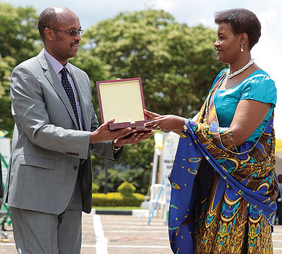 The Speaker of Parliament Donatille Mukabalisa hands over an awards to one of the taxpayers recognised  by RRA on Saturday. Twenty-three firms and individuals were also recognised by the tax body. The New Times / Village Urugwiro