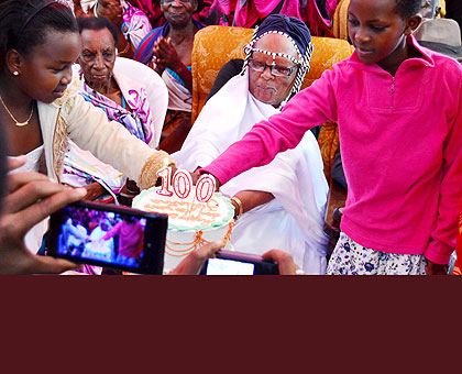 Nyiramasasa (C) and her u2018grandchildrenu2019 cut the centenarian cake. The New Times/Jean du2019Amour Mbonyinshuti