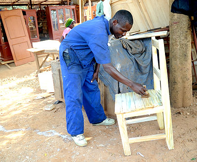 A carpentry student polishing one of his products. Education Times/ Timothy Kisambira.