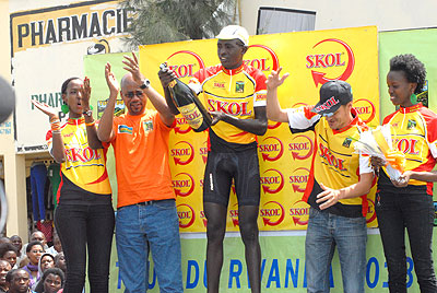 Ndayisenga pops the champagne upon winning the Second Stage of the 2013 Tour of Rwanda in Musanze yesterday. Applauding him is the president of Rwanda Cycling Federation Aimable Bayingana. Inset, Ndayisenga crosses the finish line ahead of compatriot and Karisimbi teammate Ruhumuriza. The New Times/P. Kamasa.