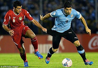 Luis Suarez (right) tussles for the ball as the Liverpool striker helps his side secure their place at the World Cup. Net photo.