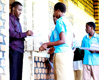 A male invigilator checks documents of candidates. The New Times/ T. Kisambira.