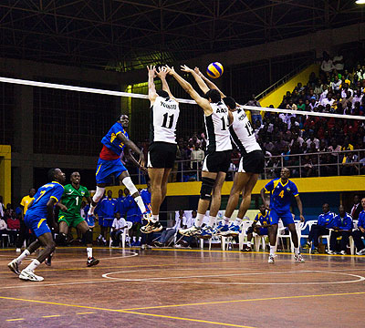 Egypt players rise in uniform in an attempt to block a spike by Rwanda's Lawrence Yakan Guma on Wednesday. Saturday Sport / T. Kisambira.