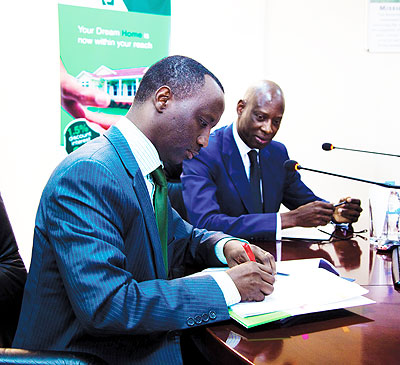 Kanyankole signs the funding deal as Ba looks on. The New Times / Timothy Kisambira
