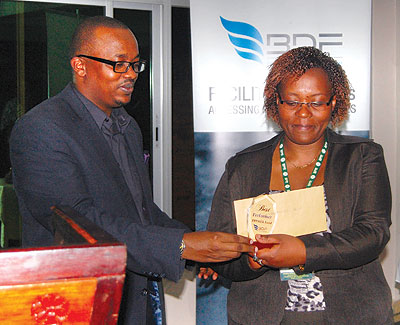 One of the managers receives her award from BDF CEO Innocent Bulindi.  The New Times / Ben Gasore