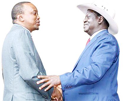 Kenyatta (L) welcomes u2018nemesisu2019 former premier Raila Odinga to Kasarani yesterday. The two political opponents are known to mend fences during national events.   Net photo.