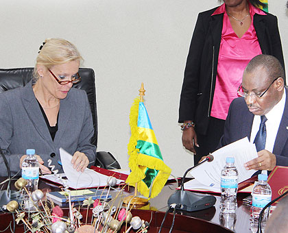 Minister Gatete (R) and Amb. Cuelenaere sign the road maintenance agreement in Kigali yesterday. The New Times/ John Mbanda.
