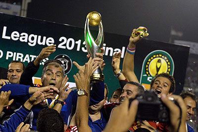 Al-Ahly coach Mohamed Youssef holds up the African Champions League trophy in Cairo on November 10, 2013. Net photo.