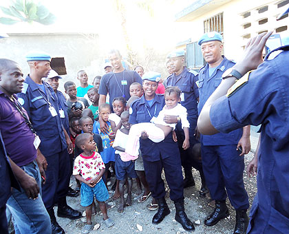 Rwanda Police peacekeepers in Haiti pose with orphans at Perpetuel Secours orphanage Centre in Jeremie on Christmas Eve after donating items. The New Times/ Courtesy