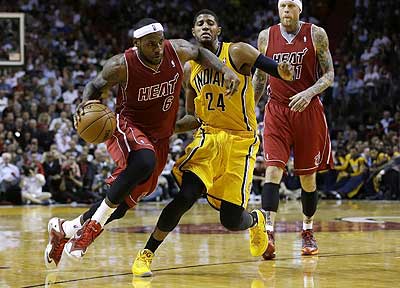 Miami Heat's LeBron James (L) drives to the basket past Indiana Pacers' Paul George during the second half of an NBA basketball game, Wednesday, December 18. Net photo.