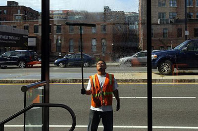 A worker washes the windows of a silver line bus station in Boston, Massachusetts.   