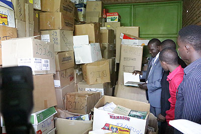Isaro Foundation officials inspect a consignment of books. Education Times / Susan Babijja.