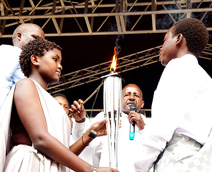 A member of Itorero, together with children of  20 years and below, light the u2018Kwibuka Flameu2019 at  Kigali Genocide Memorial Centre in Gisozi yesterday. The torch will be moved countrywide in a lap of honour and returned to Kigali on April 7 for the start of the 90 days of national mourning.    The New Times/ Timothy Kisambira.