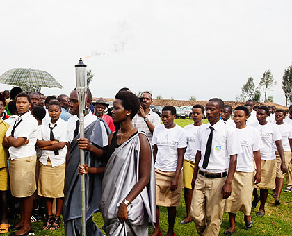 Uwishema Taise( L) and  Pacide Umuhire, students of Nyange SS, carry the torch on its arrival at the school. The New Times/ T.Kisambira.