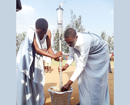 The youth who received the Kwibuka Flame in Mugina Sector anchor it in a vase ahead of the ceremony yesterday. Kamonyi residents expressed determination to strive for prosperity as they received the Flame that many called the u201cmessenger of hope.u201d The New Times/ Jean Pierre Bucyensenge.