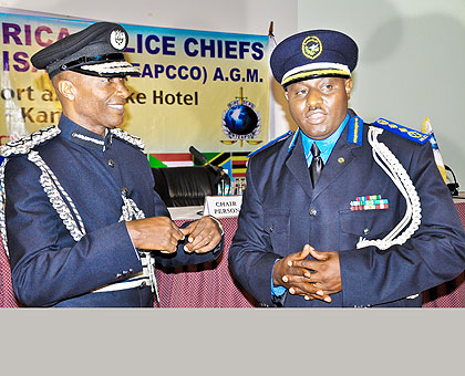 Ugandau2019s IGP Kale Kayihura (L) chats with IGP  Gasana at a past EAPCCO meeting in Kampala.   The New Times/ File.