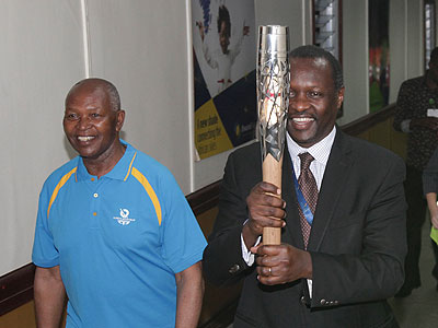 Bayigamba after receiving the Queenu2019s Baton upon its arrival at Kigali International Airport last night. Looking on is Kenyau2019s Olympic Committee chairman Dr. Kipchoge Keino who accompanied the Baton. Times Sport/John Mbanda