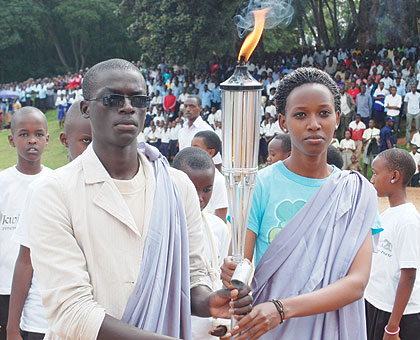 Two 20-year-olds followed by 20 children carry The Kwibuka Flame as it arrived in Huye District on Friday afternoon. The New Times/ Jean Pierre Bucyensenge.