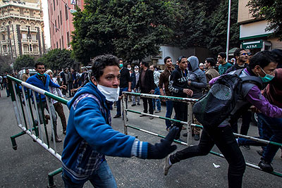 Anti-military protesters run away from tear gas fired by riot police near the Ramsis square, downtown Cairo, Egypt, Jan 25, 2014. Net photo