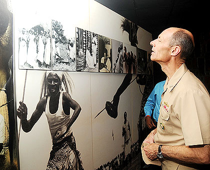 USu2019 Rear Admiral Michael T. Franken studies historical pictures inside Kigali Genocide Memorial in 2012.