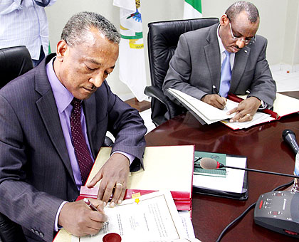 AfDBu2019s Makonnen (L) and Amb. Gatete sign the electrification deal in Kigali. John Mbanda.