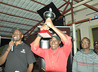 Kigali Golf club president Dr. Richard Gakuba recieves the rotating trophy from his counterpart at Entebbe Golf club Oscar Semawere (R) on Saturday. Times Sport / Courtesy.