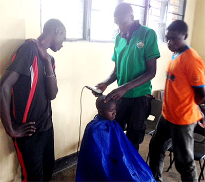 Jean Diode  Twahiirwa (middle), learns barbing skills at Centre Dushishoze, Musanze District, as fellow trainees look on. Ivan Ngoboka.