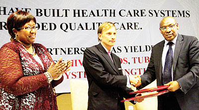 Finance minister Amb. Claver Gatete (R) shakes hands with Global Fund Executive Director Mark Dybul as Health minister Dr Agnes Binagwaho looks on. John Mbanda.