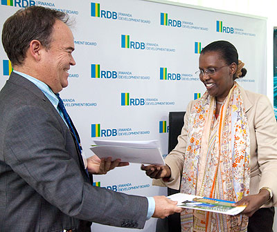 Mark Priestly of Trade Mark East Africa exchanging documents with  Amb. Rugwabiza. T. Kisambira