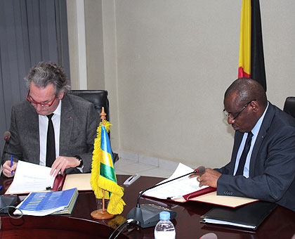 Jean-Pascal Labille and Claver Gatete sign the agreement. Courtesy