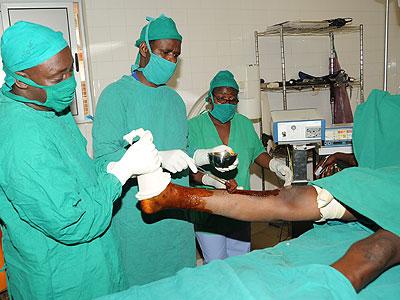 Medical workers treating a wounded person in hospital. Rwanda is the only country in the region running a public healthcare system. As a result, two Ugandan border communities rece....