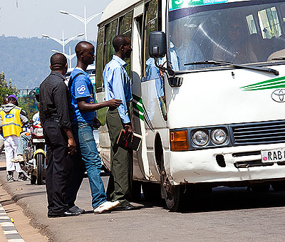 Passengers bord a bus at the Ministry of Justice bus stop in Kimihurura. T.Kisambira. 
