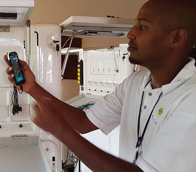 Nyakarundi demostrates how the device works (right and below). The solar powered apparatus was developed to help people who are not connected to the power grid. The New Times / Ben Gasore